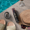 SHARK SURF in luxury pool side setting with other items such as watch, sunglasses, hat and beach slippers