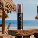SHARK SURF Sea Salt Spray bottle on beach table with ocean background